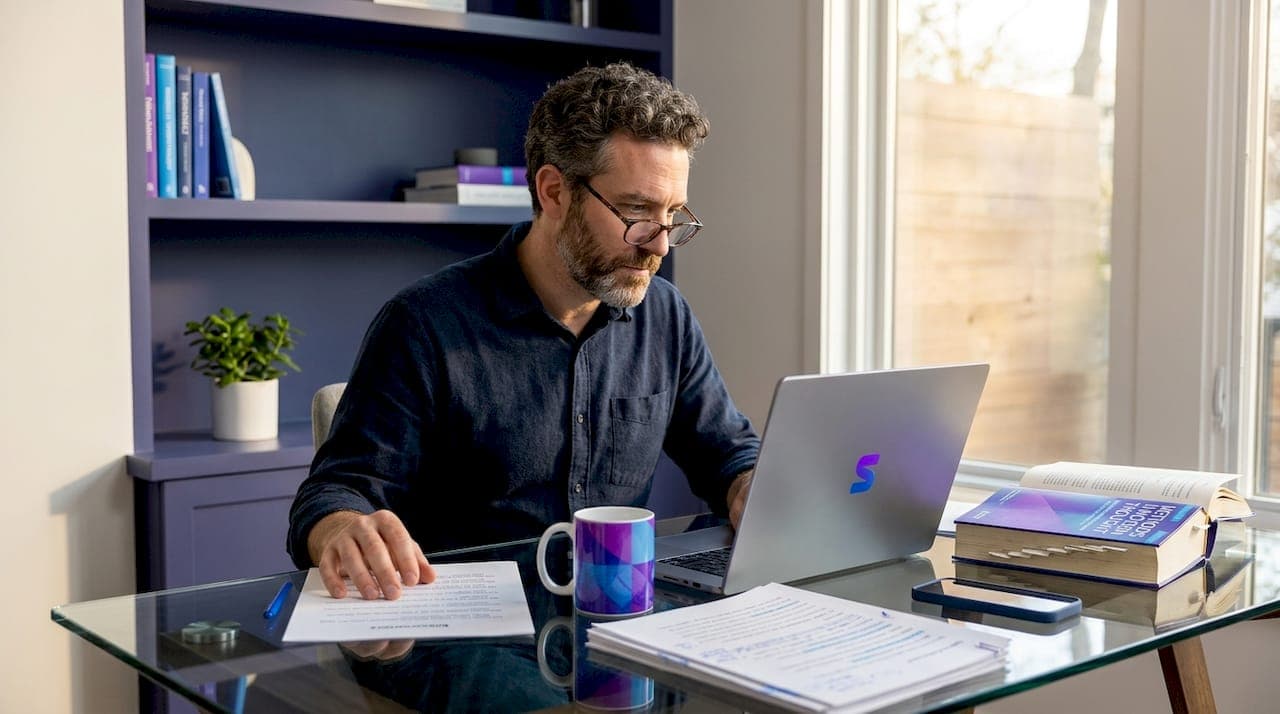 Researcher checking sources on laptop and paper
